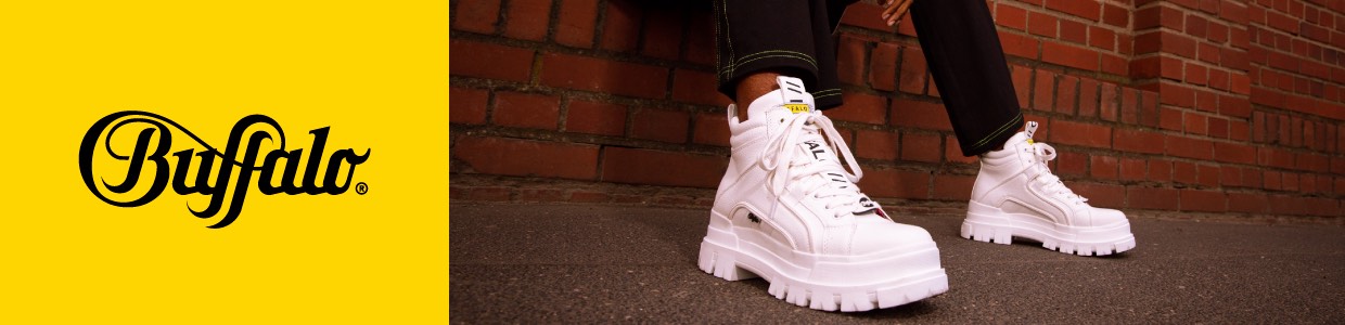 WeiÃŸe Buffalo-Schuhe vor Backsteinwand